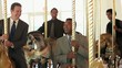 Group of smiling businessmen in suits riding carousel horses