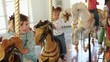 Group of smiling young girls riding carousel horses