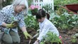 Asian grandmother teaching granddaughter to plant cucumbers in vegetable garden