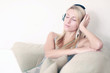 Frau auf der Couch hört Musik