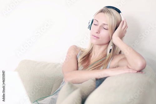 Photo: Frau auf der Couch hört Musik Frau auf der Couch hört Musik