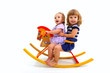 Two smiling little girls riding on a toy wooden horse isolated o