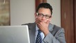 Disappointed Hispanic businessman using laptop in office