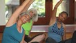 Group of mature women stretching on mats in yoga class