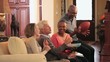 Video: Mature couples watching football on TV and eating potato chips on sofa in living room Mature couples watching football on TV and eating potato chips on sofa in living room