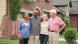 Smiling senior couples standing in front of new house