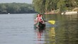 Caucasian family rowing canoe in river