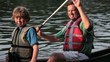Caucasian family rowing canoe in river