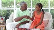 Black grandfather and granddaughter playing checkers