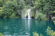 Waterfall pouring into a clear lake