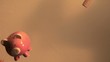 Piggy bank full of coins is thrown and smashed with sledge hammer (slow motion)