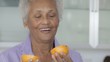 Senior African American woman smelling orange
