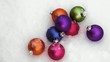 Colorful Christmas ornaments laying in snow