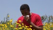 Mixed race man standing near flowers sneezing