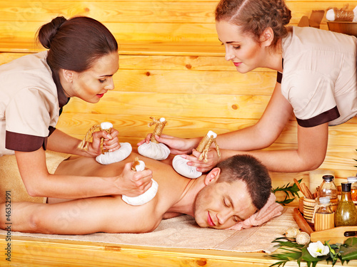 Photo: Man getting herbal ball massage treatments . Man getting herbal ball massage treatments .