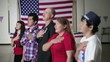 People standing in front of American flag with hands on their hearts
