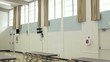 Interior of empty community center showing stage and tables with chairs