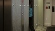 Mixed race businesswoman entering elevator