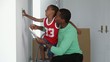 African American father with son checking paint colors