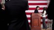 Political candidate speaking at podium and greeting awardee