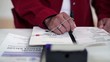 Hispanic voter's hands voting in voting booth