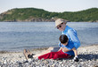 Father sitting on beach playing with disabled son