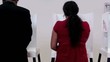 Back of voters at voting booth with one voter walking away