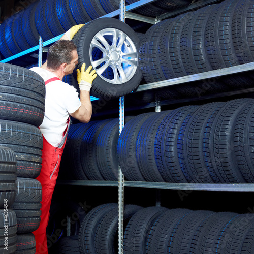 Photo: Car mechanic stores winter tires for tire changing Car mechanic stores winter tires for tire changing
