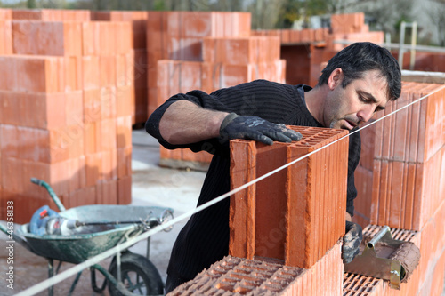 Photo: Worker building a wall Worker building a wall