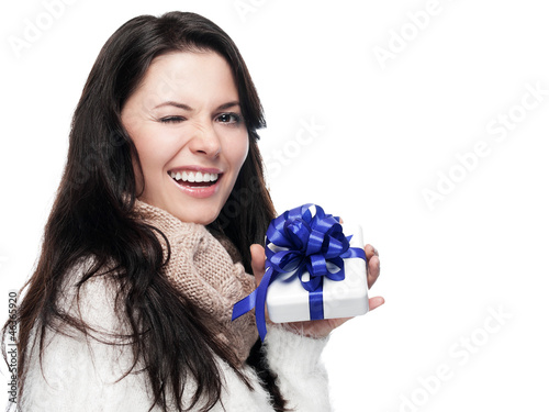 Photo: Young lady with gift winks - solated Young lady with gift winks - solated