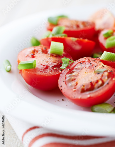 Photo: Cherry tomatoes with spring onion on a plate Cherry tomatoes with spring onion on a plate