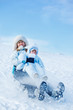 Mom and toddler sliding down the hill