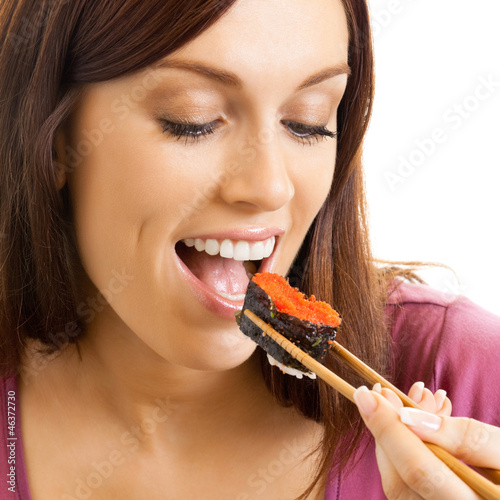 Photo: Beautiful woman eating sushi roll, over white Beautiful woman eating sushi roll, over white