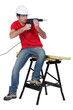 Worker aiming his power drill