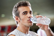 Photo: Man Drinking Water From Bottle At Health Club Man Drinking Water From Bottle At Health Club