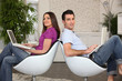 Couple in living room using laptops