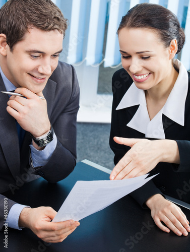 Photo: Businesspeople with documents at office Businesspeople with documents at office