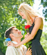 Foto: Young couple with gifts, rosa and champagne, outdoor Young couple with gifts, rosa and champagne, outdoor