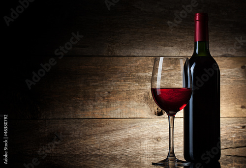 Photo: Wine glass and Bottle on a wooden background Wine glass and Bottle on a wooden background
