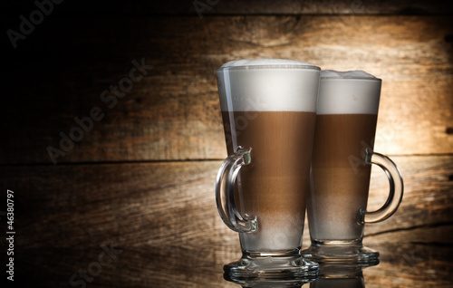 Photo: Fragrant coffee latte in glass cups on wooden background Fragrant coffee latte in glass cups on wooden background