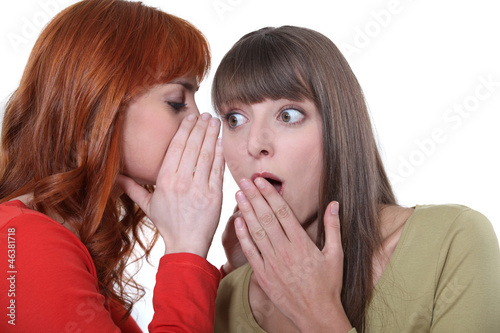 Photo: Woman whispering to her friend Woman whispering to her friend