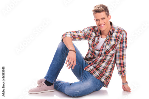 Photo: young man sitting and smiling young man sitting and smiling