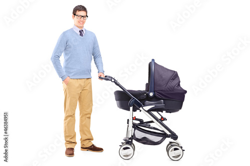 Photo: Young father holding a baby stroller Young father holding a baby stroller