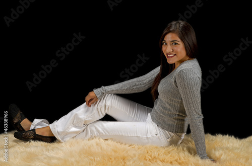 Photo: Teen hispanic girl sitting on fur rug Teen hispanic girl sitting on fur rug