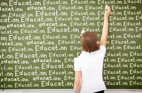 Photo: Scoolgirl standing near blackboard Scoolgirl standing near blackboard