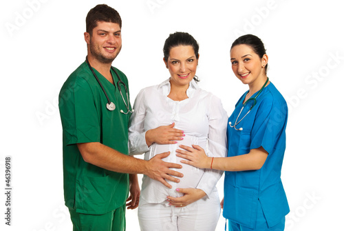 Photo: Doctors holding pregnant woman tummy Doctors holding pregnant woman tummy