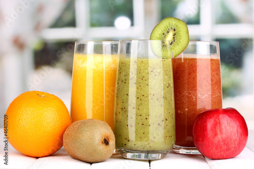 Photo: fresh fruit juices on wooden table, on window background fresh fruit juices on wooden table, on window background