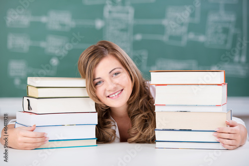 Photo: schülerin mit bücherstapeln schülerin mit bücherstapeln