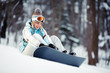 Young woman strapping on Snowboard