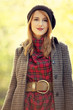 Style redhead girl at beautiful autumn alley.